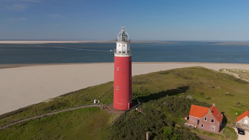 Texel lighthouse during sunset Netherlands Dutch Island Texel in summer. iconic red lighthouse in the dunes of Texel with a blue sky