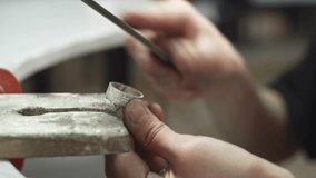 A jeweler uses a file to align a piece of jewelry in the form of a silver ring. Craft in a jewelry workshop - Powered by Shutterstock - Get 15% off with code: PIKWIZARD15