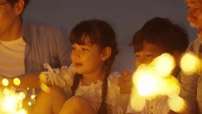 4K Happy Asian family travel nature the sea on summer beach holiday vacation. Multi-Generation family enjoy and fun outdoor lifestyle playing sparklers firework together on tropical beach at night. - Powered by Shutterstock - Get 15% off with code: PIKWIZARD15