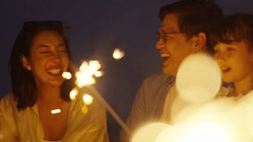 4K Happy Asian family travel nature the sea on summer beach holiday vacation. Multi-Generation family enjoy and fun outdoor lifestyle playing sparklers firework together on tropical beach at night. - Powered by Shutterstock - Get 15% off with code: PIKWIZARD15