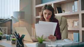 Company leader working computer holding papers. Pensive businesswoman solving problem typing laptop in financial agency. Frustrated young executive browsing checking market analytics in office room - Powered by Shutterstock - Get 15% off with code: PIKWIZARD15