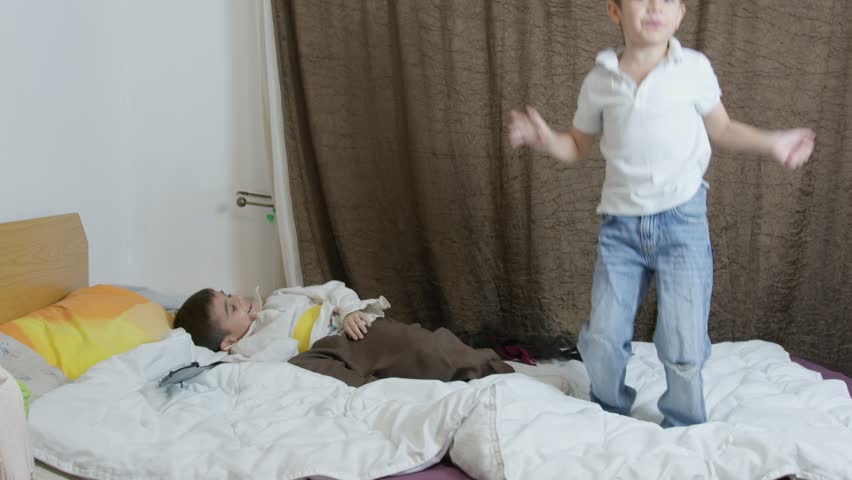 Cute children playing pirates. Younger brother jumping on the bed as a winner in pirate fight then goes to check on his brother who is relaxing. High quality 4k footage