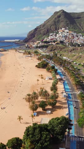 Aerial view of the Las Teresitas beach and San Andres resort town in Tenerife, Canary Islands, Spain. Yellow sand beach, palm trees and coastal road. 