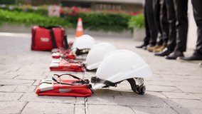 The image focuses on the essential equipment, with white safety helmets placed on the ground, ready for use. In the background, we see the rescue personnel, distinguished by their sturdy equipment. - Powered by Shutterstock - Get 15% off with code: PIKWIZARD15