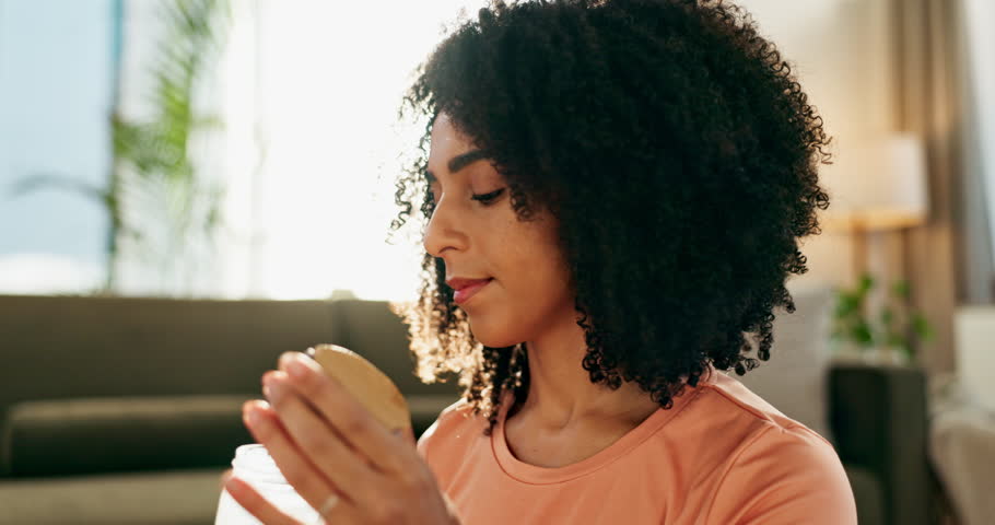 Yoga, black woman and drinking water in home for wellness, hydration and fitness break for nutrition or healthy habits. Girl, bottle and self care routine with lens flare and natural detoxification.