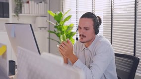 Asian professional businessman using laptop computer video call in office. Attractive handsome professional male employee worker sitting on table working and talking with customer at night in company.