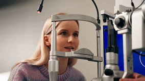 in an ophthalmology clinic young girl communicates with a doctor through a diagnostic machine - Powered by Shutterstock - Get 15% off with code: PIKWIZARD15