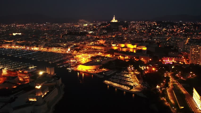 Panoramic night view of the old port and Notre Dame de la Garde Cathedral, city of Marseille in South France