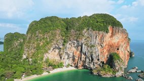 Drone video of the beautiful Railay Beach in Thailand. View of an idyllic beach with huge limestone cliffs, turquoise ocean, tropical island from above