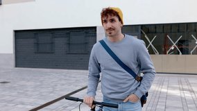 Happy young man walking with bicycle in the exterior area of a business center. Entrepreneur people and commuting concept. - Powered by Shutterstock - Get 15% off with code: PIKWIZARD15