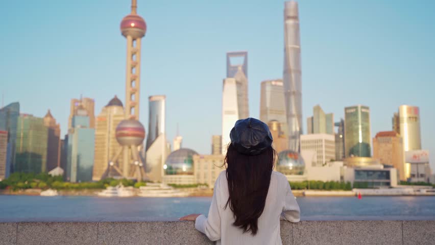Young female tourist relaxing and looking beautiful modern city at Shanghai, China