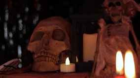 Human skull, skeleton doll and burning candles in dark, Dia de Muertos. - Powered by Shutterstock - Get 15% off with code: PIKWIZARD15