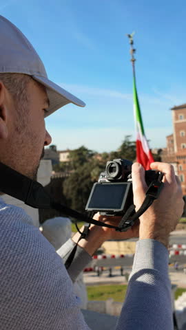 Man filming the streets of Rome, Italy from a high point. Vertical