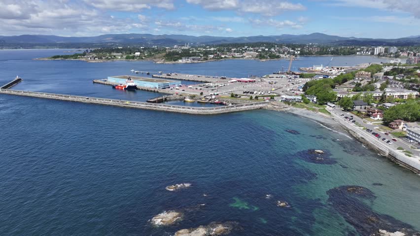 right panning across James Bay district, Victoria from Ogden Point Pier till Holland Point Park with Downtown Victoria and other districts in background, aerial video footage Vancouver Island, BC 