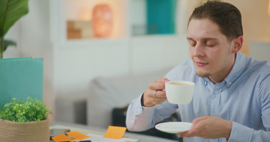 Businessman enjoys the taste of coffee while working successfully in the office