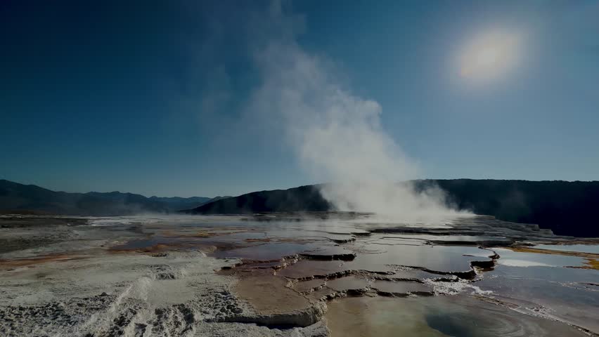 Yellowstone Park with rushing geysers, multicolored hot springs, crystal clear lakes and impressive canyons. Bears and bison. Wyoming, Idaho and Montana. Yellostone natural spectacle. Sunset.