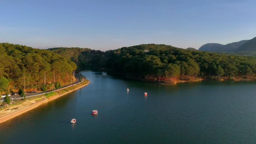 People in relax time with duckboat, boat in duck shape on Tuyen Lam lake in pineforest, cool weather, fresh air, green jungle so romantic for honeymoon of couple when travel to Dalat