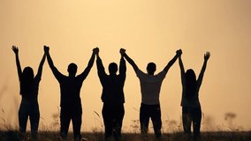 Silhouette people holding hands. Group united at sunset. Celebrating success freedom together. Bonding in nature. Teamwork and unity outdoors. People enjoying moment freedom. People success freedom. - Powered by Shutterstock - Get 15% off with code: PIKWIZARD15
