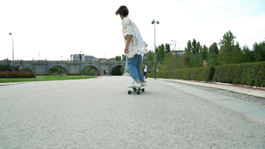 Captured in slow motion, a woman glides gracefully on her longboard, showcasing fluid movements and elegant balance.