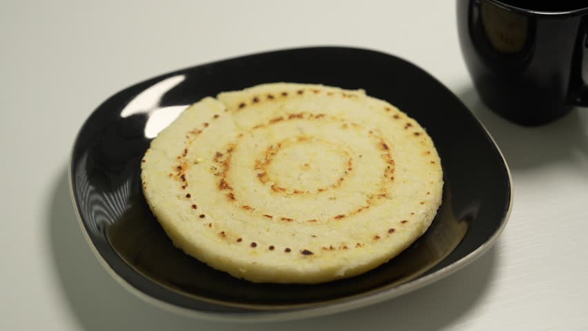 Colombian Traditional Breakfast. Adding Cheese on Top of Arepa. Close Up