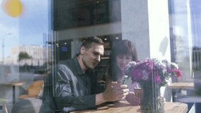 Happy Young woman sitting with boyfriend at cafe table, discussing over on smartphone, Young couple looking at mobile phone shopping online and share information together in coffee shop. - Powered by Shutterstock - Get 15% off with code: PIKWIZARD15