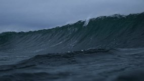 Rough stormy ocean wave crashes into green barrel on dark grey day - Powered by Shutterstock - Get 15% off with code: PIKWIZARD15