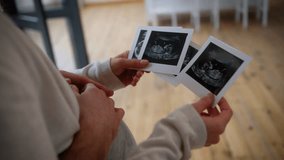 Unrecognizable couple watching ultrasound pregnancy test photo USD pictures indoors at home unknown man pregnant woman girl guy male female parents future mother father family anticipation baby child - Powered by Shutterstock - Get 15% off with code: PIKWIZARD15