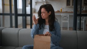 Caucasian woman hungry girl female at home couch sofa unpack open paper bag package food delivery cafe order meal spoiled stink odor bad smell smelling awful smelly dish unpleasant sad disgust dislike - Powered by Shutterstock - Get 15% off with code: PIKWIZARD15