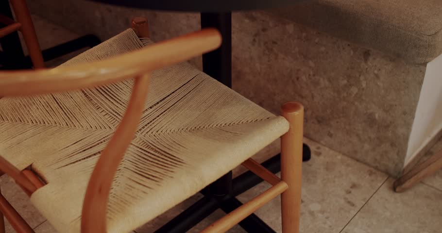 Modern minimalist cafe with wooden chair with textile material. Close up wooden and fabric chair. Eco Friendly Cafe. Empty dining fabric and wooden chair. Modern wooden with fabric furniture in cafe.