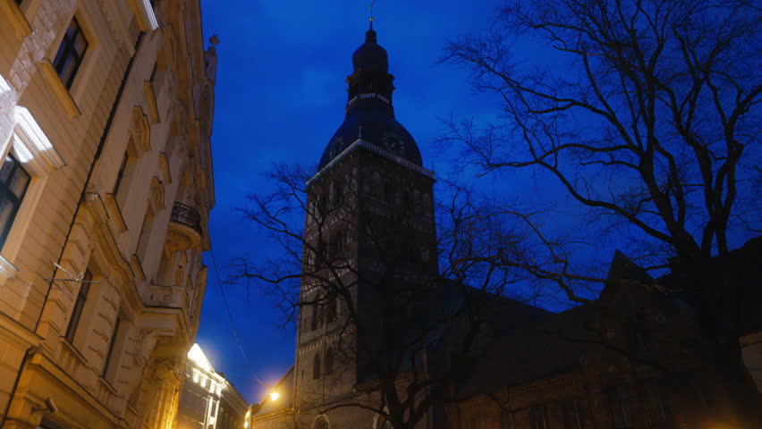Historic church tower glowing in dusk, serene in the city with a hint of mystery and spirituality