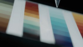 Designer scrolling through color palette and shades of red and orange on a tablet. Slow motion.  - Powered by Shutterstock - Get 15% off with code: PIKWIZARD15