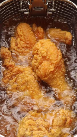 Deep fry chicken drumstick in deep fryer. frying in hot boiling oil. Close up shot
