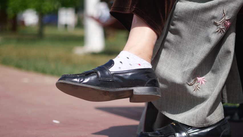 Young woman putting on shoes at outdoor .