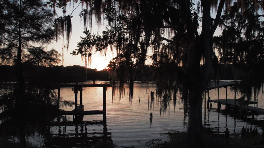 Aerial: Drone Panning Shot Of Trees In Rippled River Stream Against Clear Sky During Sunset - Bayou Vista, Texas