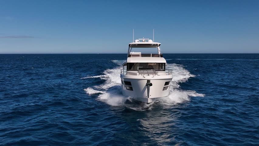 Slow motion drone shot of luxury boat driving straight filmed from the front side