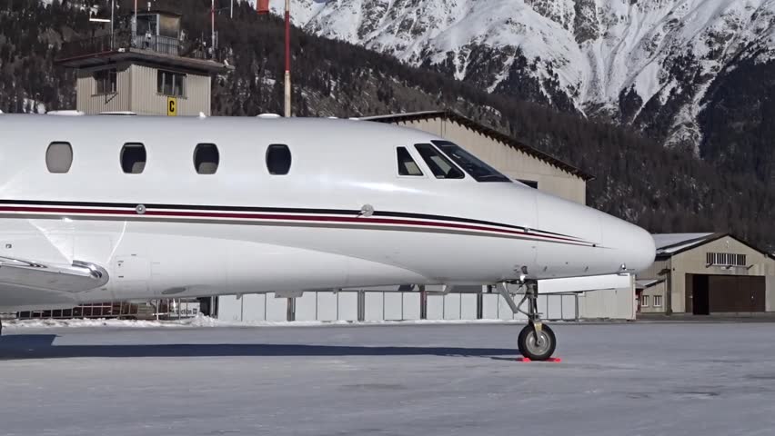 Slow panning shot of Business Jet parked at Airport Snow