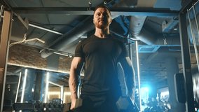 A determined man doing dumbbell lateral raises at the gym. Strength, focus, and fitness dedication are evident as he works on his shoulder muscles in a well-equipped gym environment. - Powered by Shutterstock - Get 15% off with code: PIKWIZARD15