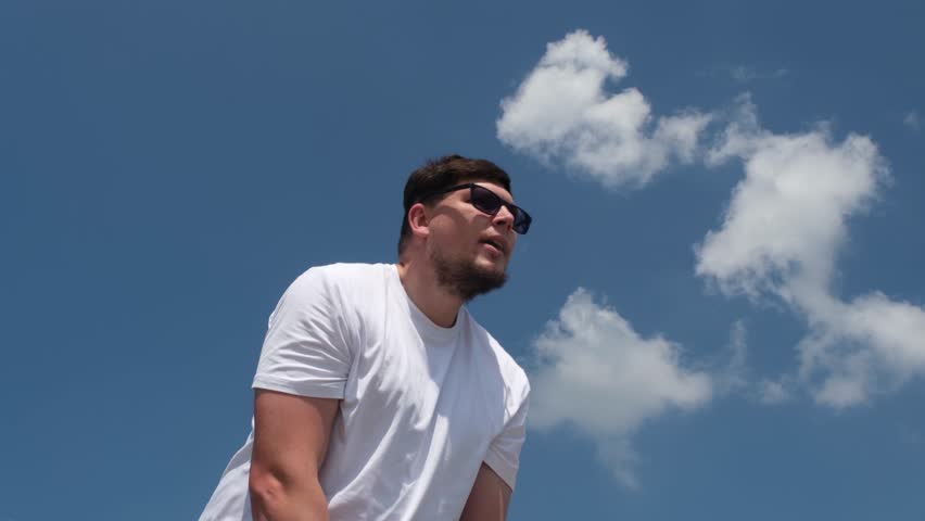 sports and leisure. strong Caucasian man working out using kettlebell in the park, sky background
