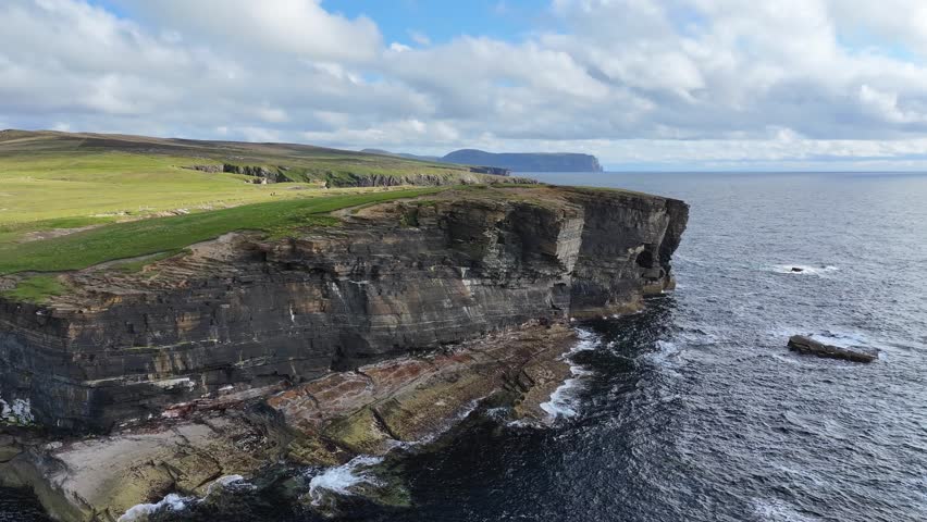 Aerial View of Picturesque Shoreline of Scotland UK, Cliffs, Caves and Green Pastures Above Sea Waves