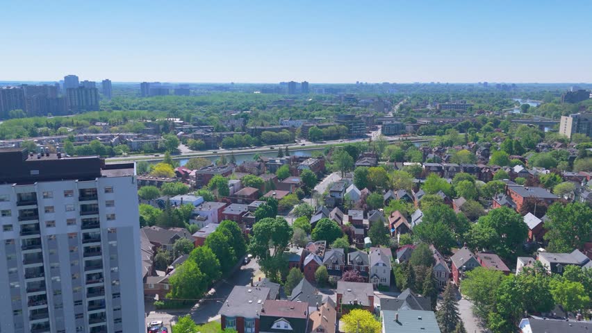 Bustling aerial view of cityscape over Ottawa, showcasing a harmonious blend of high-rise buildings and residential areas, interspersed with verdant green spaces