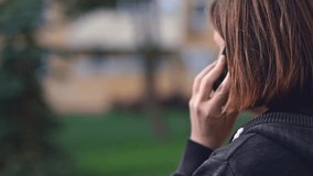 Confidential and private phone call, adult brunette female talking on mobile phone outside, selective focus - Powered by Shutterstock - Get 15% off with code: PIKWIZARD15