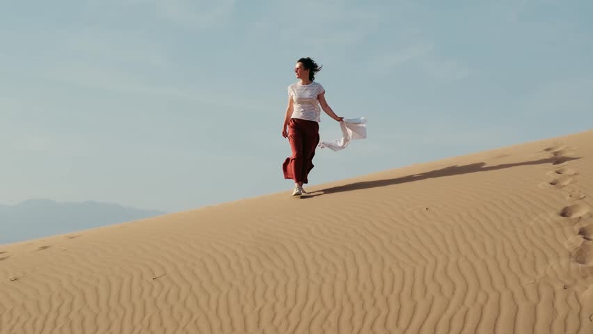 Young beautiful european woman walking in desert landscape