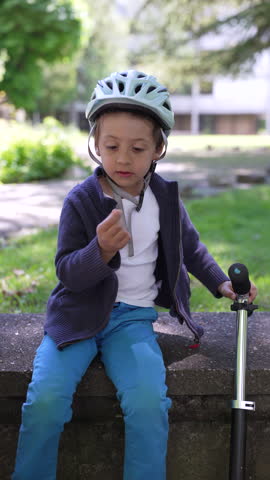 Mother breastfeeding newborn on a park bench while older child interacts, showcasing a loving and nurturing moment in an outdoor family setting