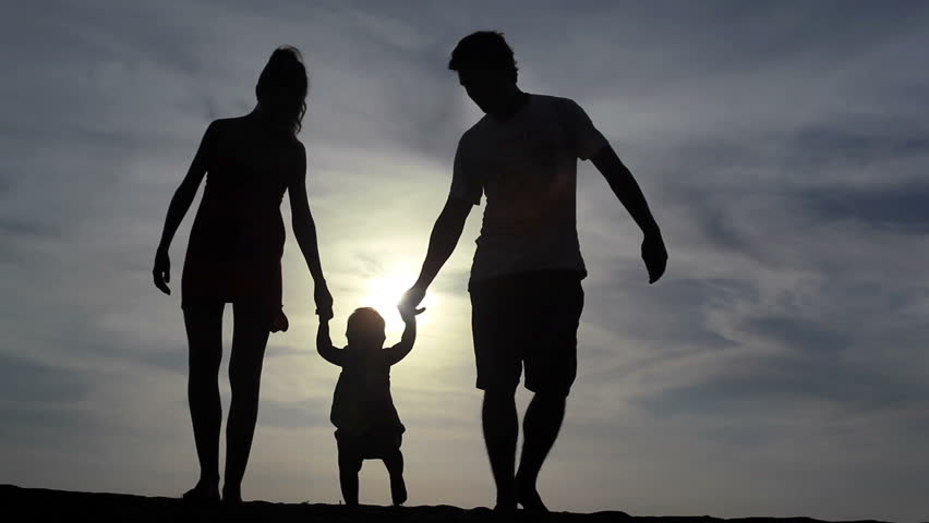 Silhouette of family walking together at summer
