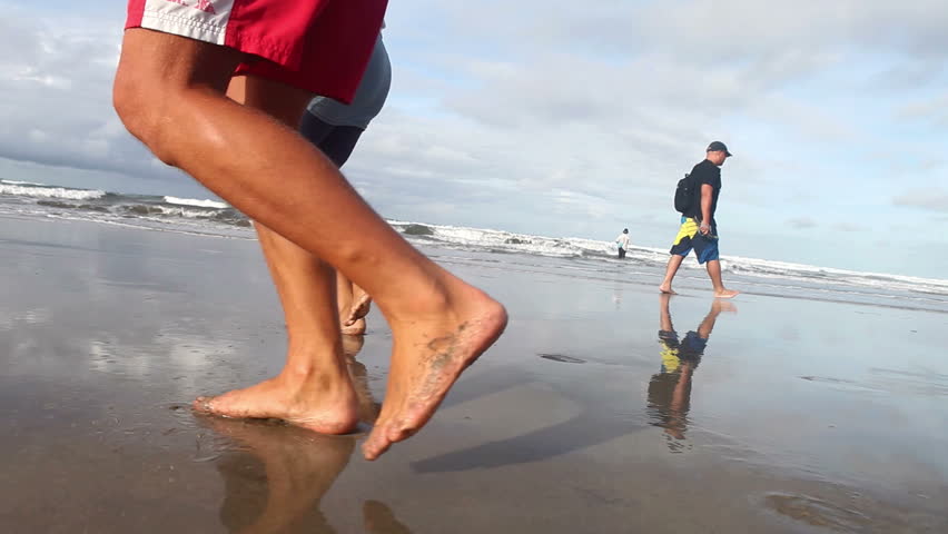 Couple legs running together at seaside
