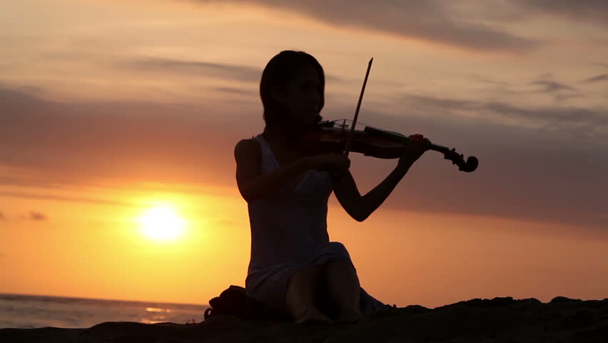 Violinist playing on violin. romantic music at sunset.