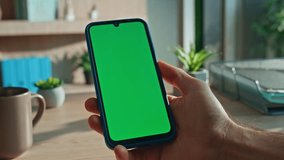 Smartphone user looking green screen display at office desk close up. Unrecognizable businessman hand holding chroma key cellphone at work break. Manager checking email on mobile phone at morning. - Powered by Shutterstock - Get 15% off with code: PIKWIZARD15