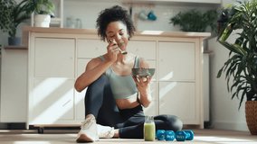 Video of athletic woman eating a healthy fruit bowl while sitting on floor in the kitchen at home - Powered by Shutterstock - Get 15% off with code: PIKWIZARD15