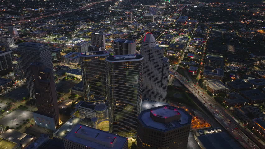 Houstons dazzling cityscape at night from above. Glide over lit skyscrapers of 1400 Smith St. and 1500 Louisiana St. and busy streets in this vibrant urban scene