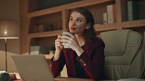 Pensive manager drinking tea sitting dark office desk with laptop close up. Smiling businesswoman enjoying hot beverage working late evening. Successful entrepreneur thinking on business perspectives. - Powered by Shutterstock - Get 15% off with code: PIKWIZARD15